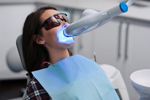 京橋 銀座みらい歯科でオフィスホワイトニングのライトを前歯に当てる女性のイメージ